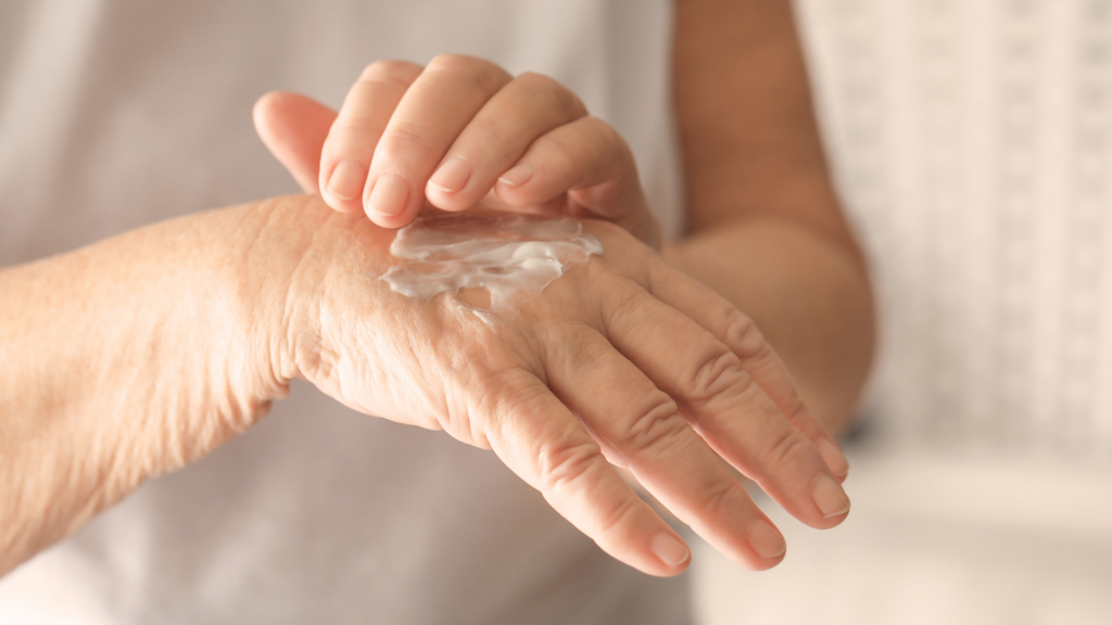 une femme âgée qui met de la crème sur ses mains